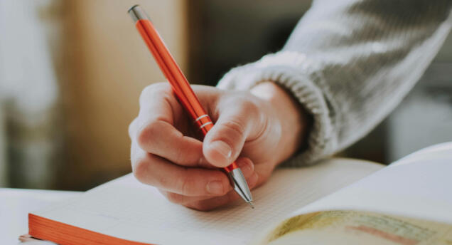 **Inspiration vs. Copycatting** hand holding a pen to write on a notebook